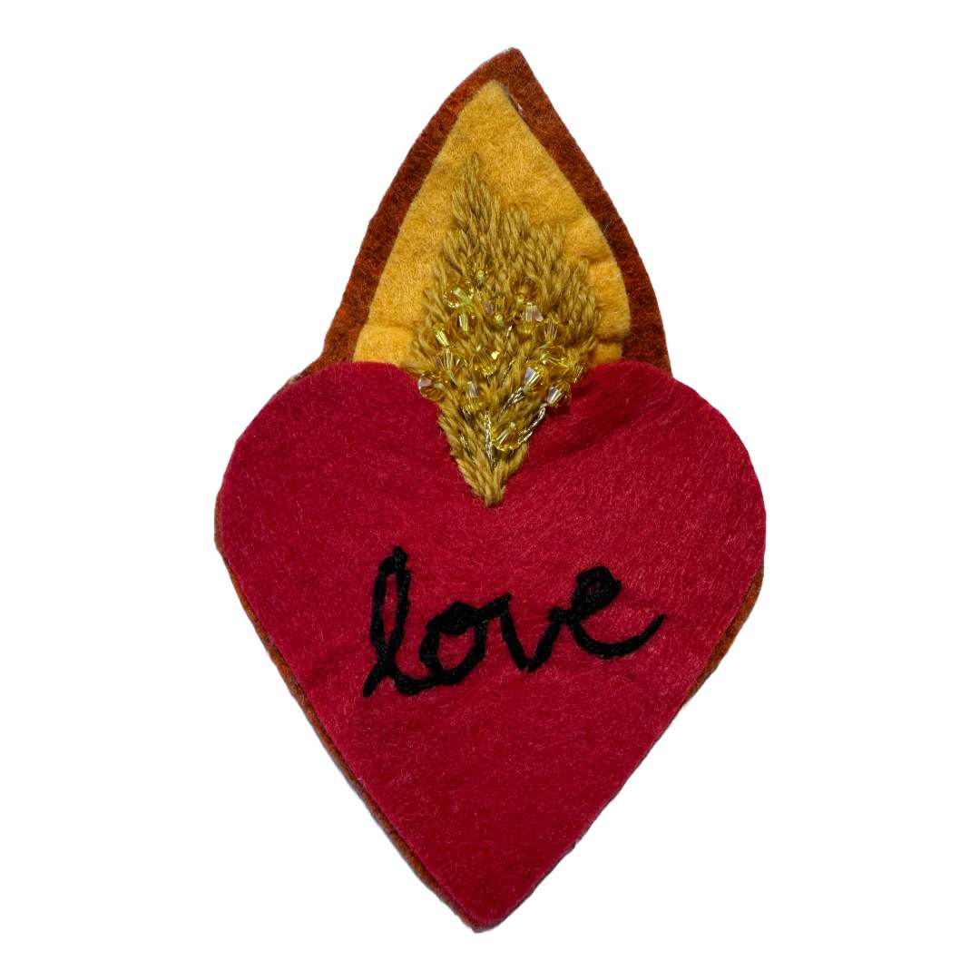 little love by Andrea Dupree  Image: In this collection of wearable and displayable fiber artworks, I explore the intersection of the metaphysical and the material world. Each piece serves as an altar, inviting the viewer or wearer to step into a space of reflection, intention, and spiritual connection.  I am deeply inspired by sacred imagery relating to the heart and eyes; in my work these are considered as protective elements. 

The fiber elements of the altars are crafted primarily from materials chosen for their sustainability and connection to the earth including DMC Eco-Vita wool thread, inherited/thrifted embroidery flosses and wool felt. The Eco-Vita organic wool thread is dyed using infusions of natural ingredients such as walnut, rhubarb, indigo, and juniper. 

Each piece is sturdy, lightweight and versatile; they can adorn clothing, bags, hats, walls, tabletops or (for the pieces with clips) hair. I've offered similar pieces at pop up markets in Santa Fe and online since 2023; what I love about these pieces is how they resonate with people of all ages. 