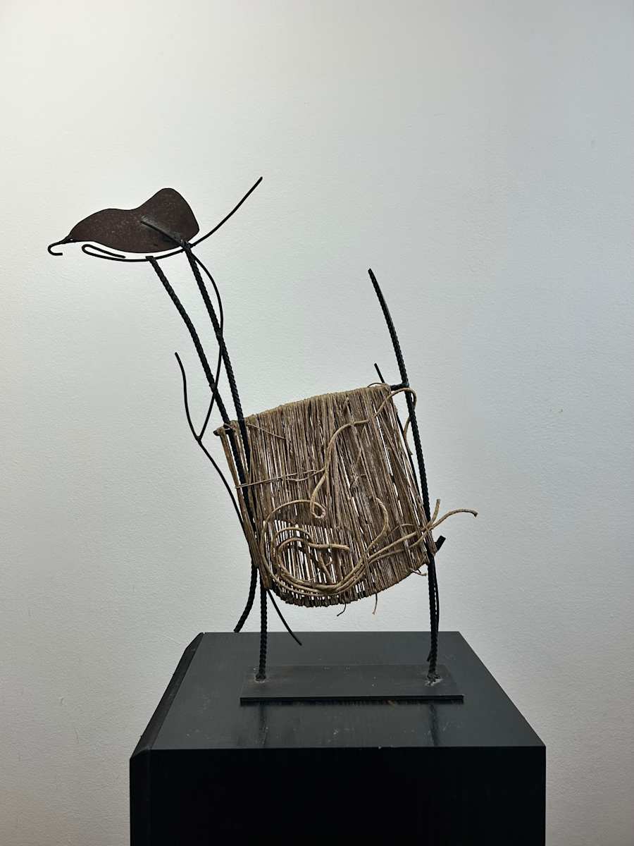Untitled by Ruggero Gamberini  Image: In this delicate and poetic sculpture, Ruggero Gamberini combines raw iron rods, a curved metal form, and hand-wound twine to create an organic tension between strength and fragility. The piece suggests both botanical and anatomical associations, with the textured spago (string) evoking nests, fibres, or vessels. Its asymmetrical poise lends a sense of gentle movement, as though swaying in a silent current. 