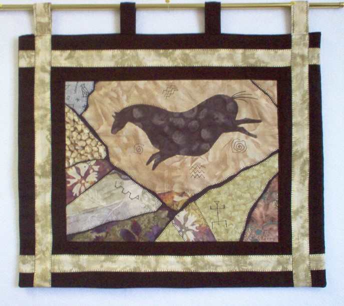Ancient Rocks by Katrina Sjoberg  Image: A collage made up of batiks and machine stitched with an ancient horse image and framed in fabric.