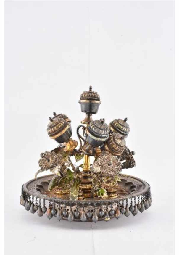 Perfume Container (Attar dan)  Image: A treasure of courtly refinement, this extraordinary silver attar dan dazzles with flower-shaped lids, delicate wirework, proud peacock motifs, and touches of green lacquer. Once holding precious perfumes, it embodies the sensory elegance of India’s regal past. A comparable example is illustrated in Mughal Silver Magnificence, p. 88.
