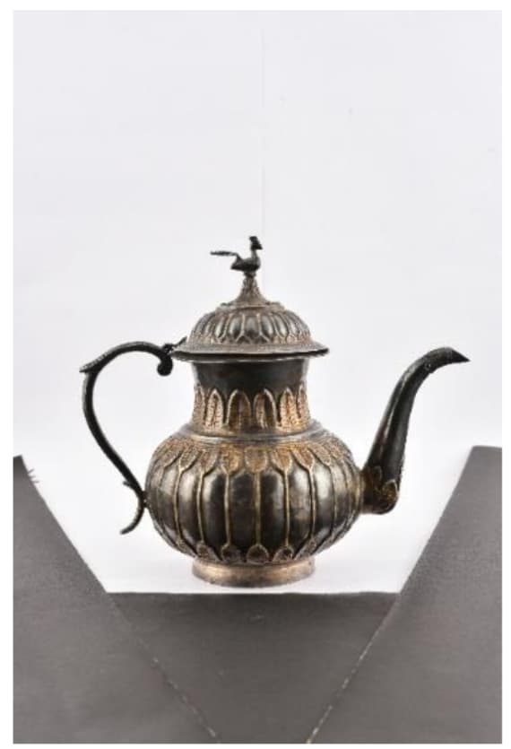 Ewer  Image: This parcel-gilt silver ewer features a bulbous body with chased acanthus borders, a curved handle, and a domed lid crowned by a peacock finial on a lotus rosette.