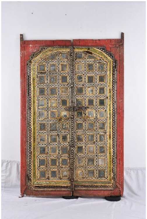 Door  Image: This Mughal door shimmers with mirrored panels framed in gold-plated silver, bone inlay evoking jāli latticework, and vibrant enamel blooms edged in gold. Arched and richly bordered, it reflects a fusion of Persian influence and imperial craftsmanship.

