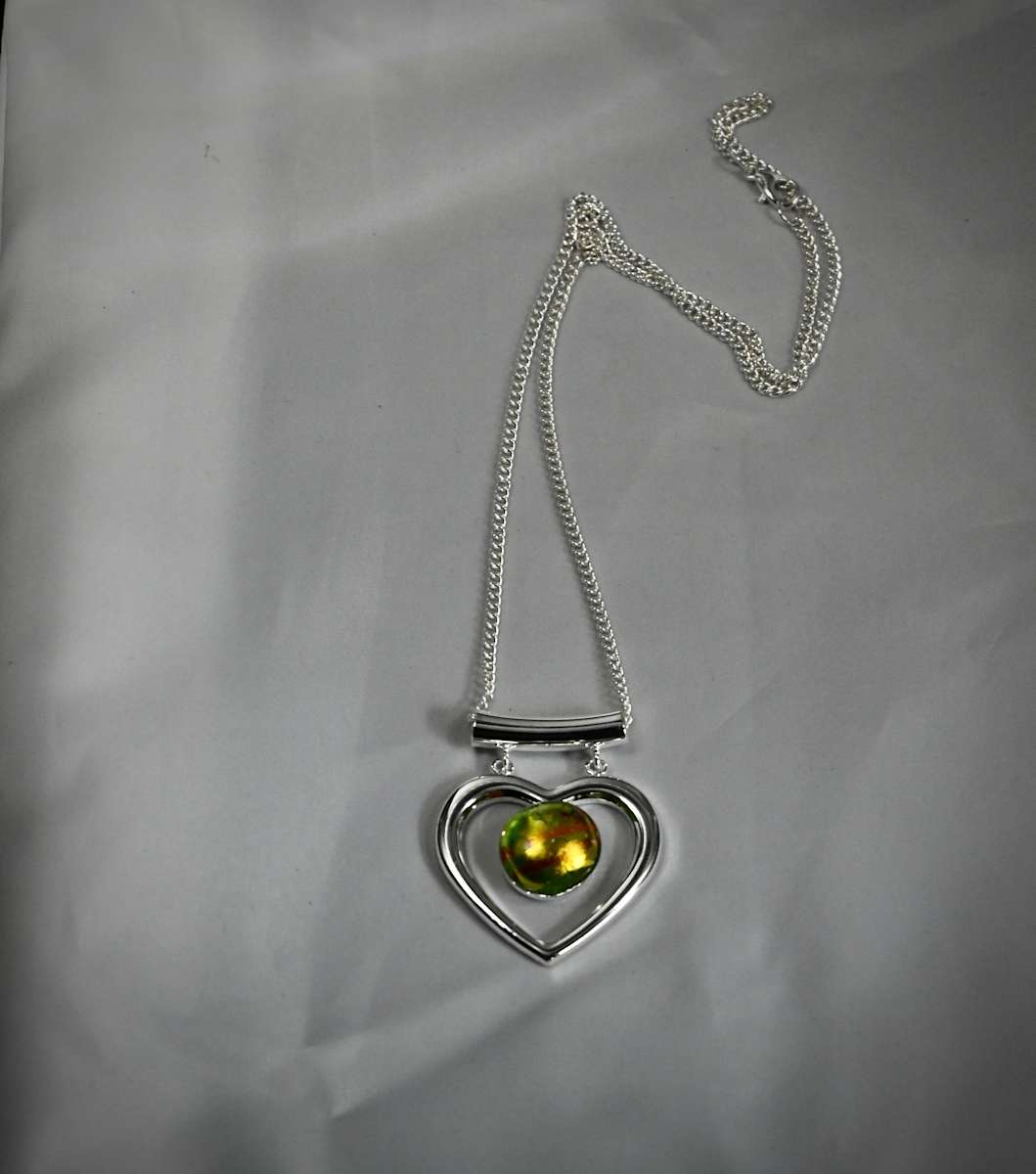 Heart Pendant by Susan Mason  Image: top view heart pendant with golden glow from light
