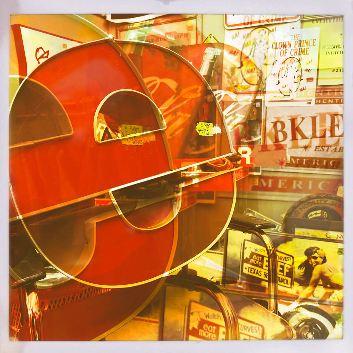 E as in Red by Sherry Ross  Image: The layers in this image weave an unlikely tale—part typography, part beef, part crime drama. In truth, it’s simply the quirky juxtaposition of posters, signage, and one enormous light-up letter E—a collision of visual fragments that somehow feels like a story waiting to be told.  The warm color shift evokes the look of a vintage photograph, gently worn and faded after half a century, enhancing the nostalgic charm of the vintage ephemera.