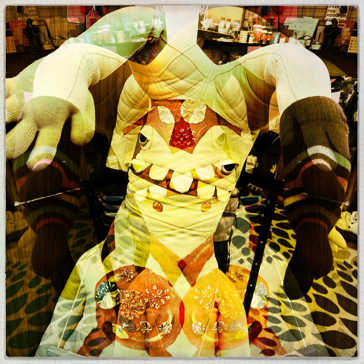 Floppy Head by Sherry Ross  Image: On my travels, I came across a massive fiber doll adorned with a delightful patchwork of bright colors. Its whimsical form made me laugh the moment I saw it. As much as I loved it, there was simply no room in my life—or my home—for a five-foot-tall fiber art piece. Instead, I decided to photograph it and experiment with a multiple exposure, using distortion and repetition to highlight its vibrant patterns and playful form.

The layers overlap and merge, creating new forms and unexpected images, while the muted, warm palette evokes the gentle nostalgia of a well-loved photograph. Designed to stir comfort and memory, it invites the viewer to regard it as one would an old friend.