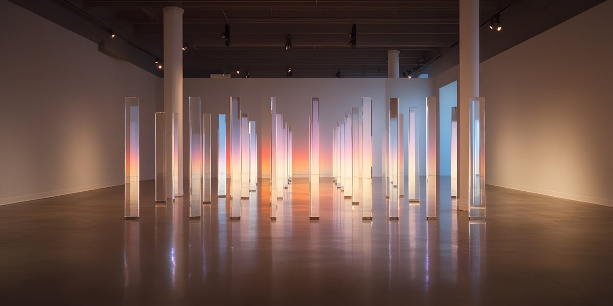 Pillars of the New Sun by Sabine Korrin  Image: A field of luminous glass columns fading from warm amber to cool violet, catching and scattering light like the shifting edge of dawn.