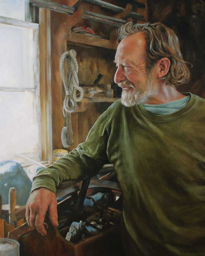 Portrait of Boat Builder and Designer Nat Benjamin by Elizabeth R. Whelan  Image: Boat builder and designer Nat Benjamin is a delightful fellow, and a very gracious portrait subject. I happened by chance to depict him in a corner of the boat shop where he keeps his own tools, and for the painting I chose a moment where the light catches the structure of his profile as he watches the work out on the marine railway.