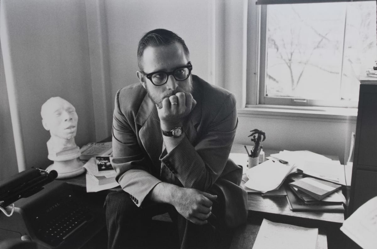 Dr. Pfeiffer by H. Landshoff  Image: A black and white portrait of a man sitting on a desk.