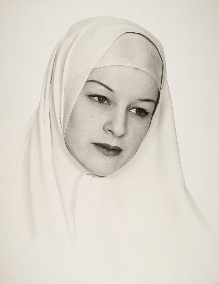 Religieuse by Shirley Hall  Image: A black and white portrait of a woman wearing a white silk veil that wraps around the top of her head and under her chin. 