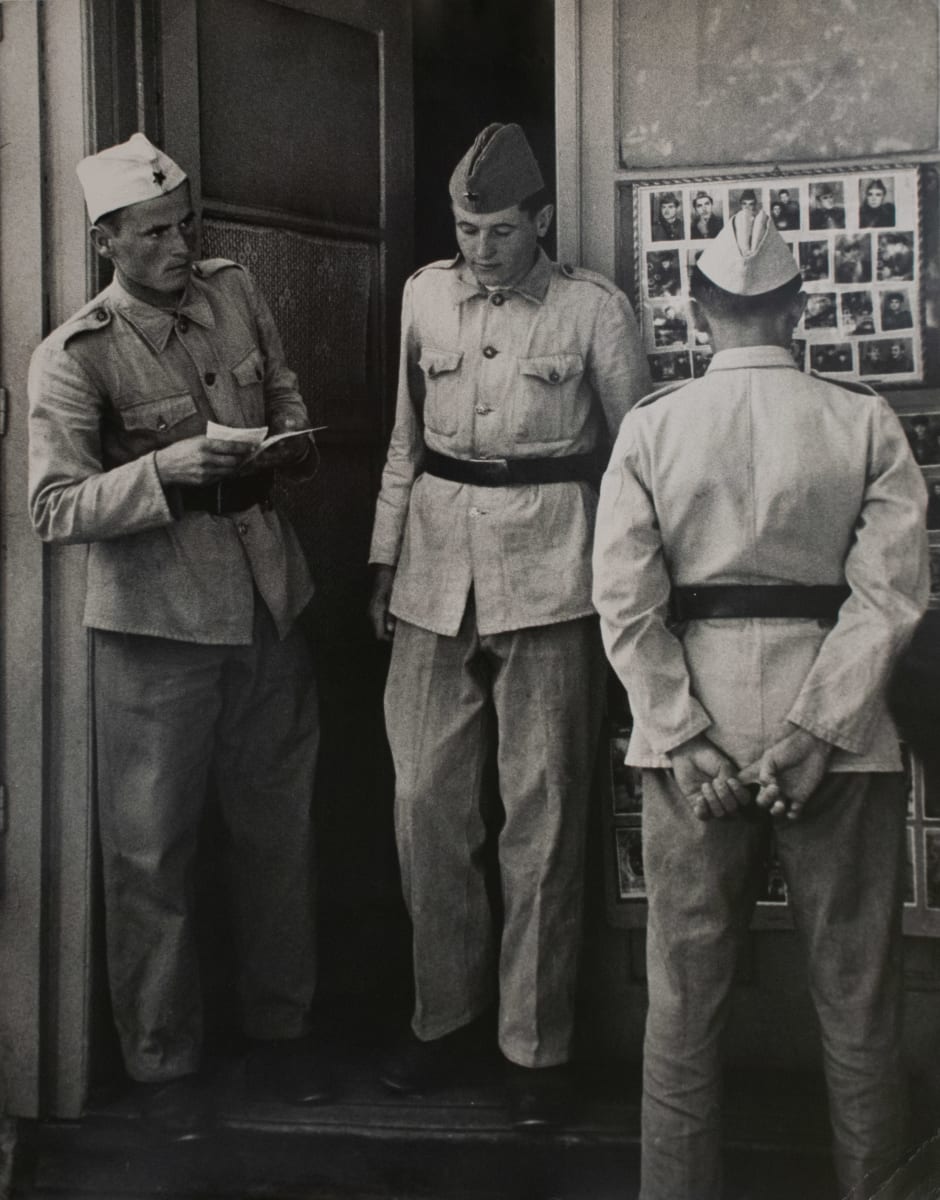 Belgrade Yugoslavia 1956 by Edward R. Miller  Image: Three soldiers, one rear view, looking at photos, two in doorway.