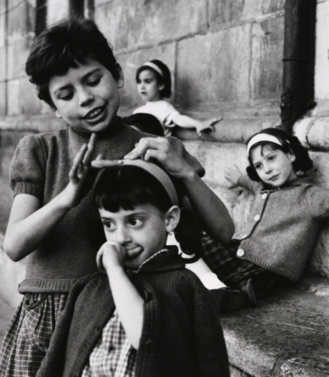 Oviedo, Spain 1962 by Edward R. Miller  Image: Four white children by a stone wall- one fixing another's hair