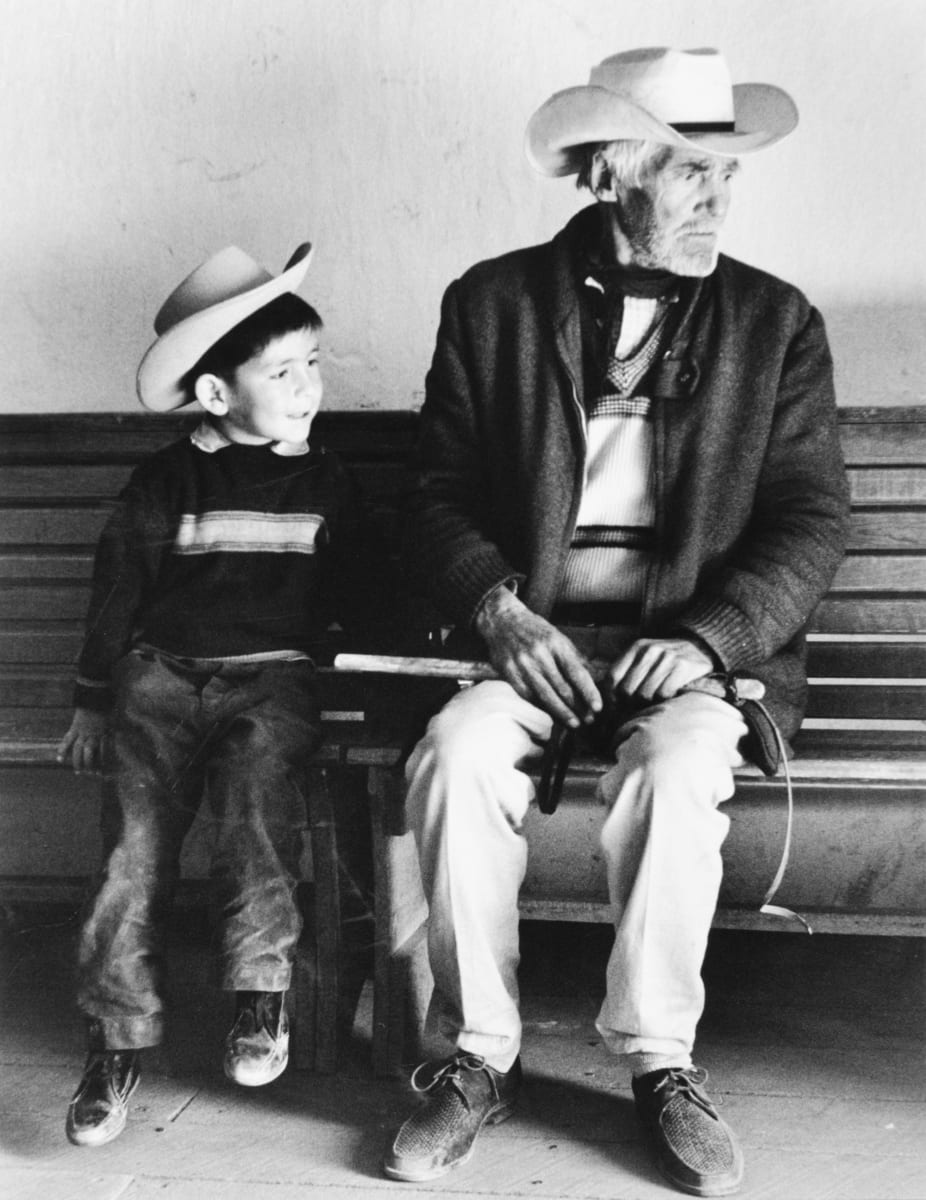 281 Creel, Mexico 1967 by Edward R. Miller  Image: White old person and child in cowboy hats sitting on a bench.