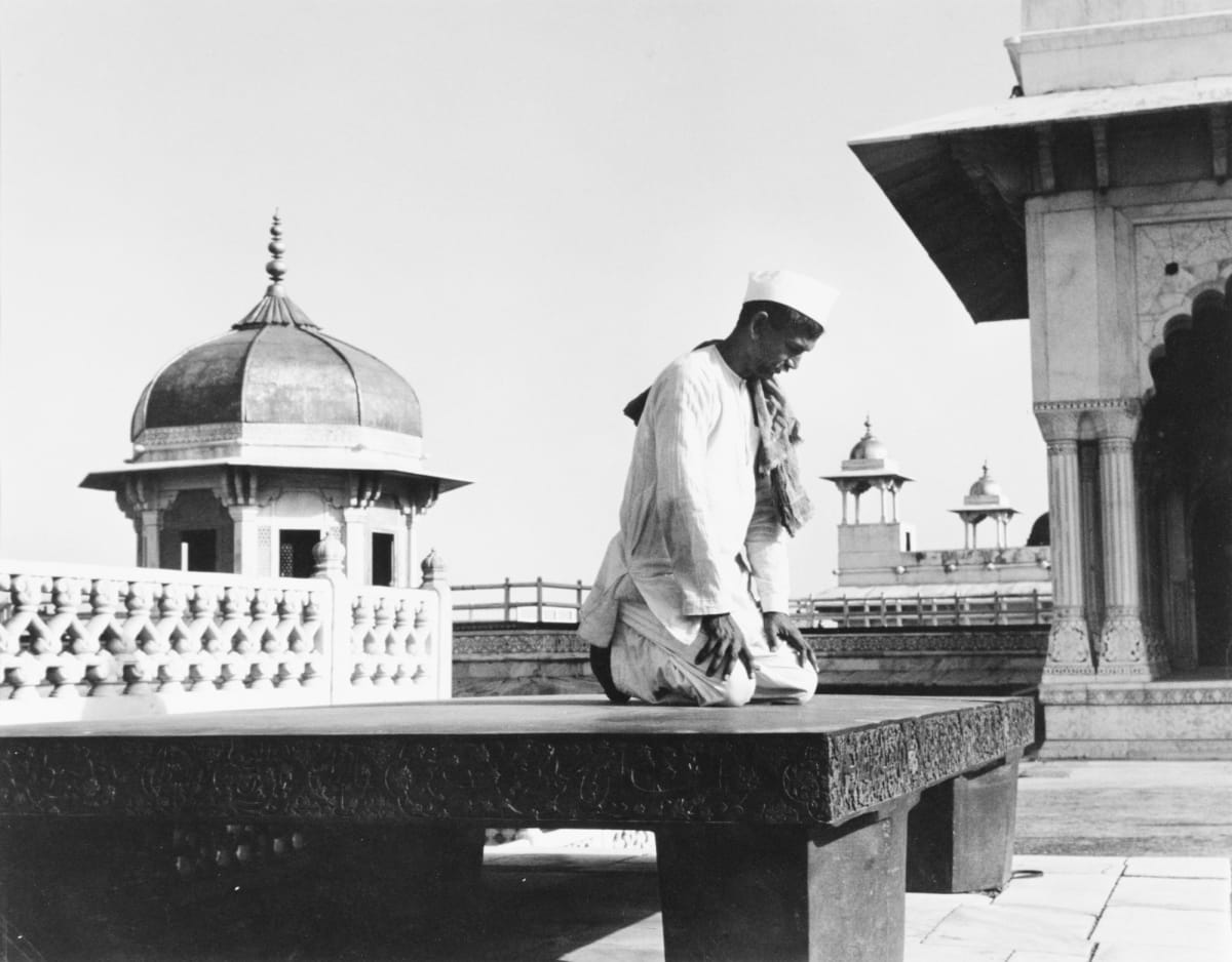 Agra, India 1950 by Edward R. Miller  Image: Indian person kneeling on a stone slab on temple grounds praying.
