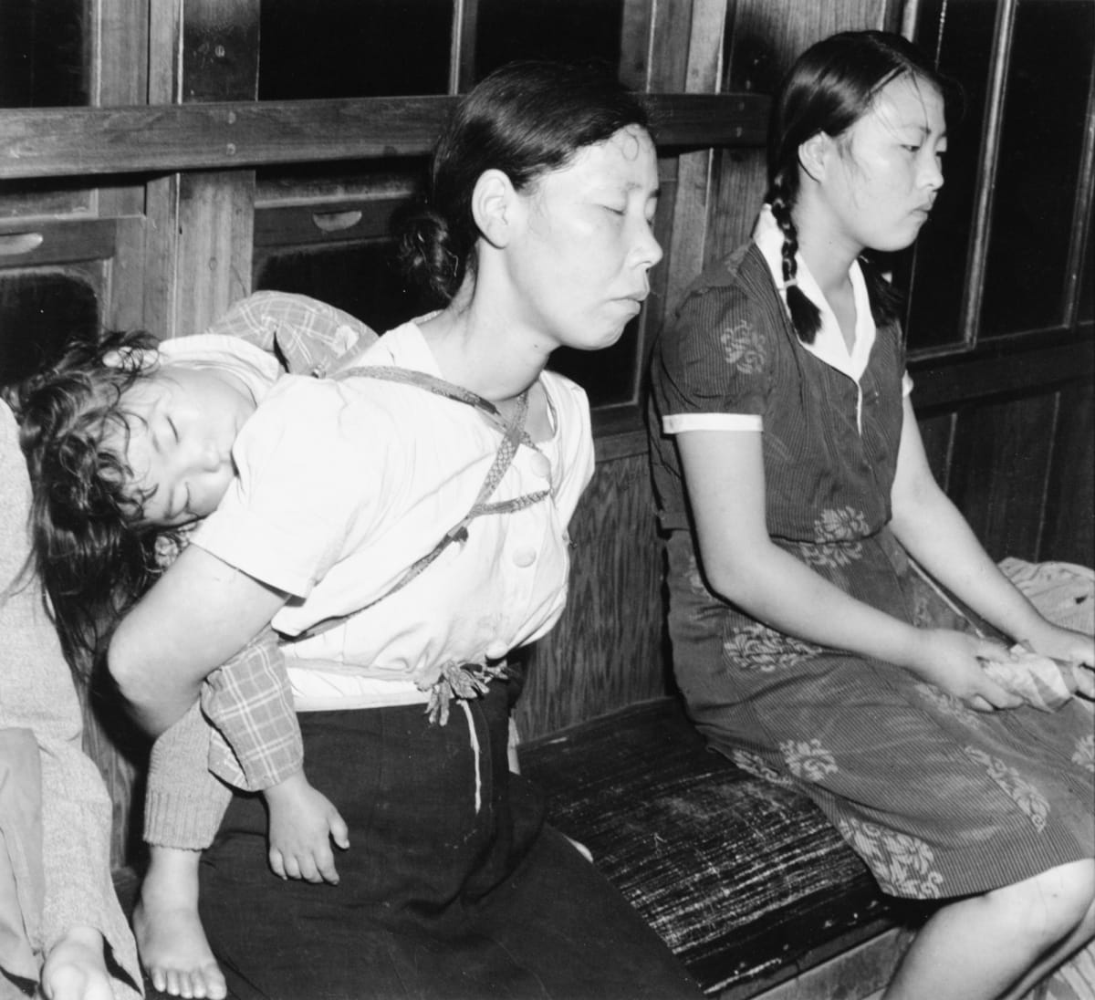 Tokyo, Japan 1948 by Edward R. Miller  Image: Two Japanese people on old wooden subway seat, child on one persons back sleeping