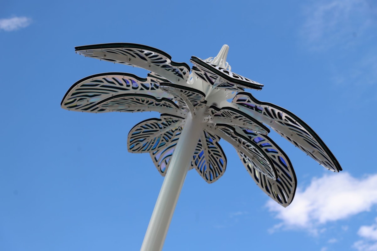 Metal flower sculpture with colorful glass inlaid in the petals.