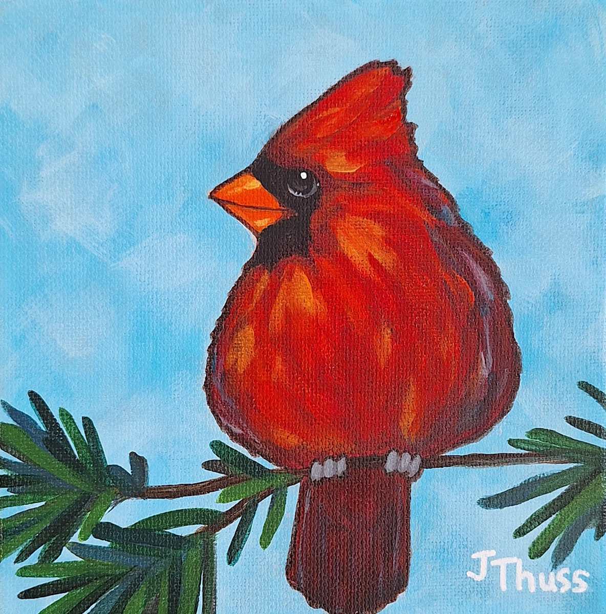 Feathered Flame by Jane Thuss  Image: A red cardinal perches on a pine branch, it’s bright feathers glowing warmly against the quiet hush of winter.