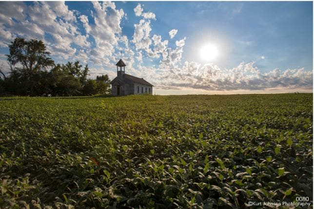 Sun over Church and Crops by Kurt  Johnson 