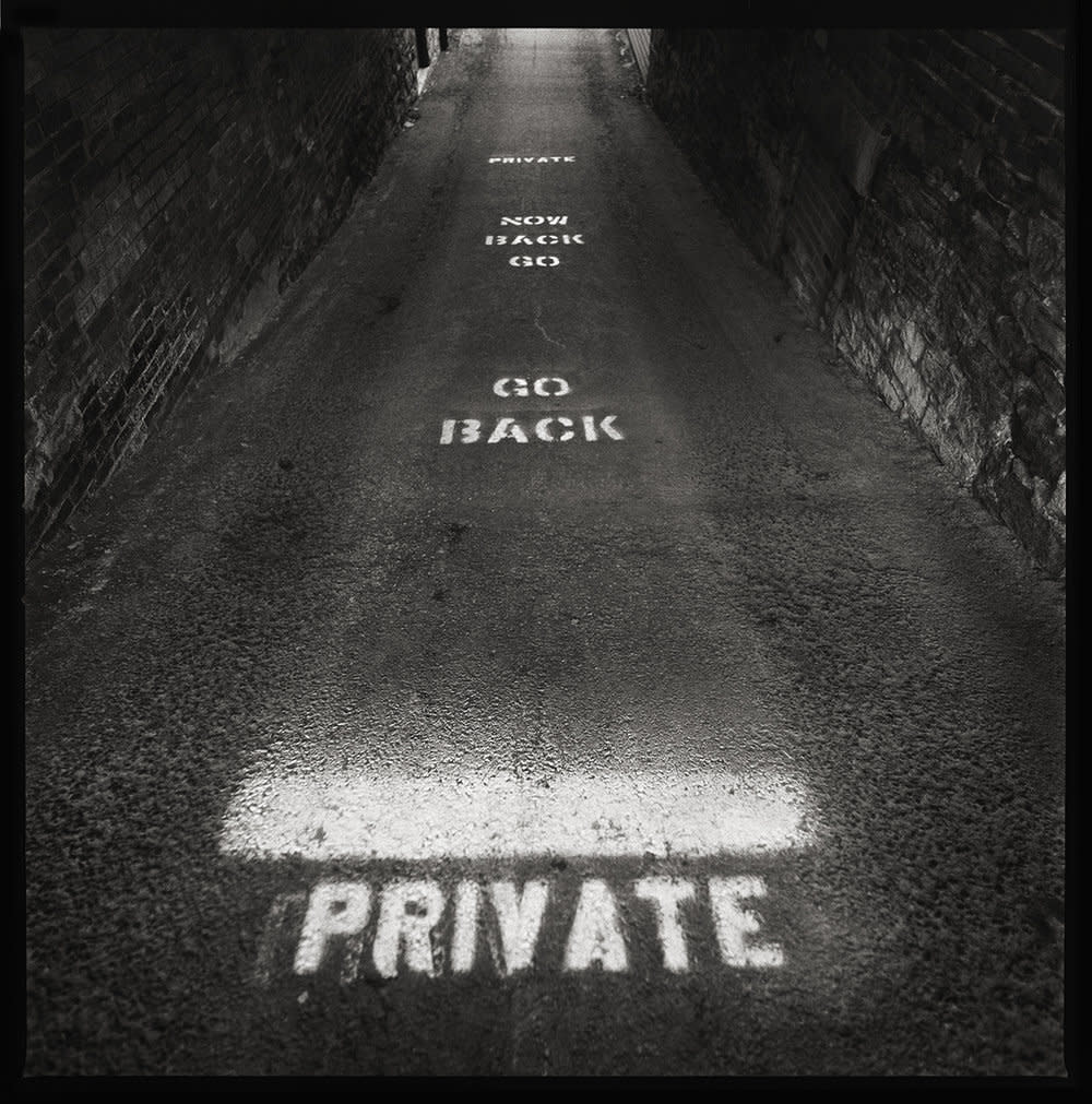 PRIVATE | Now Back Go : Go Back | PRIVATE by Eric T. Kunsman  Image: ID: A black and white image shows a floor that reads "PRIVATE" "NOW GO BACK" "GO BACK" "PRIVATE".  The floor and the little that can be seen on the walls is dark grey and the words are all white.
