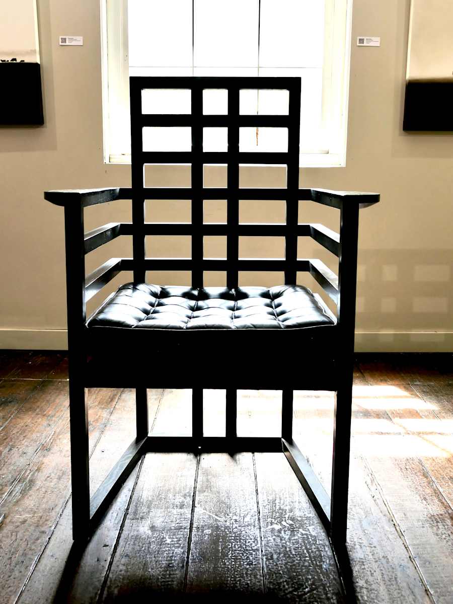 Pair of Josef Hoffman Armloffel Chairs by Josef Hoffman  Image: These highly collectible chairs designed in 1908 by Josef Hoffman, built by Wittmann, Austria with makers plaque under the seat.  Stained black oak with black leather buttoned upholstered pads and studding. 