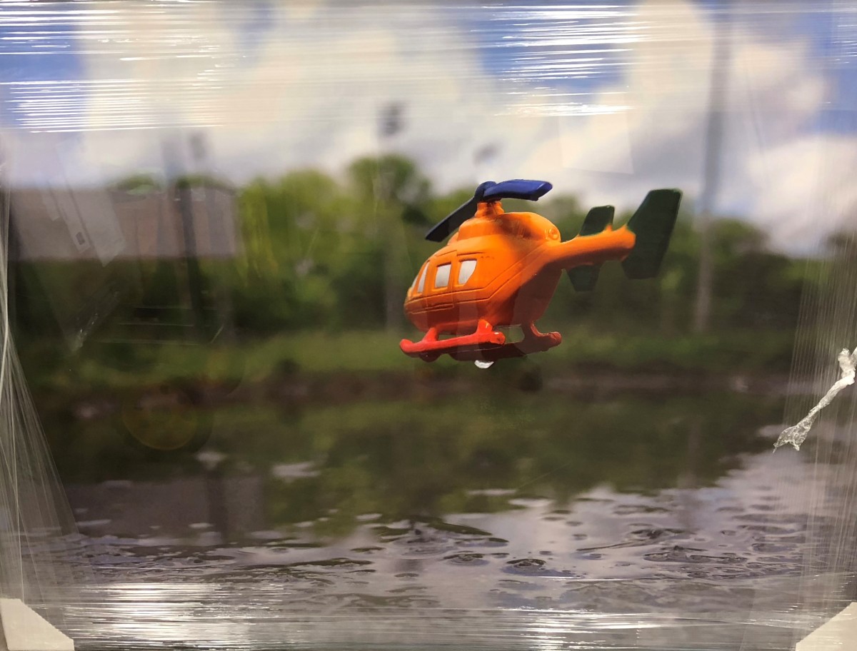 Inches Above Earth Series "Approximate Altitude ? Inches " (Orange Helicopter over Water) by Michael Reese 