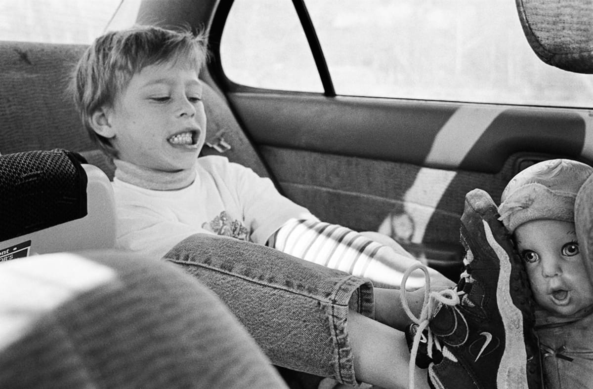 Ernie with his sister's doll, Vermont, When Kids Witness Violence, from Living with the Enemy by Donna Ferrato 