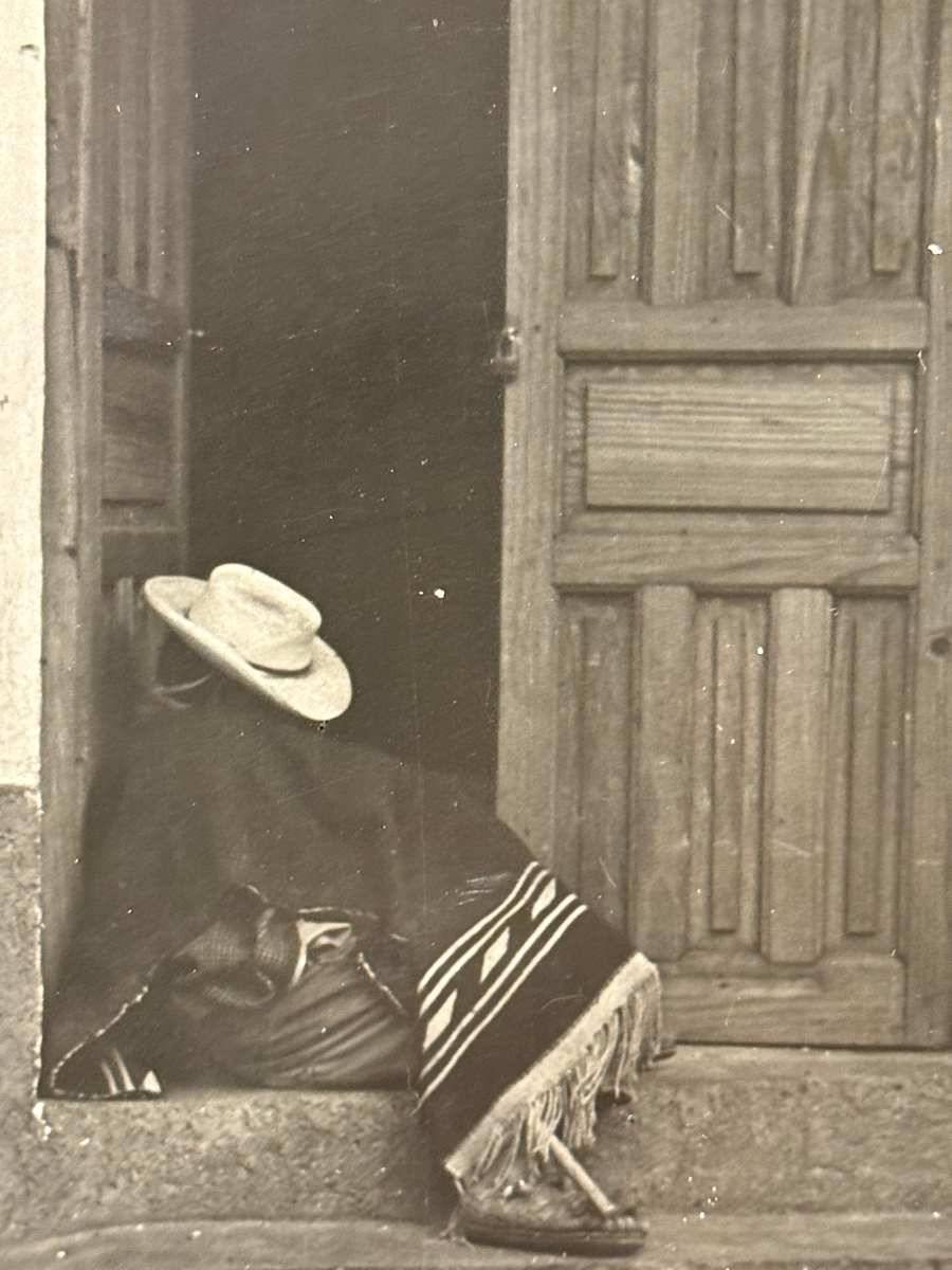 black and white photograph seated figure in a doorway 