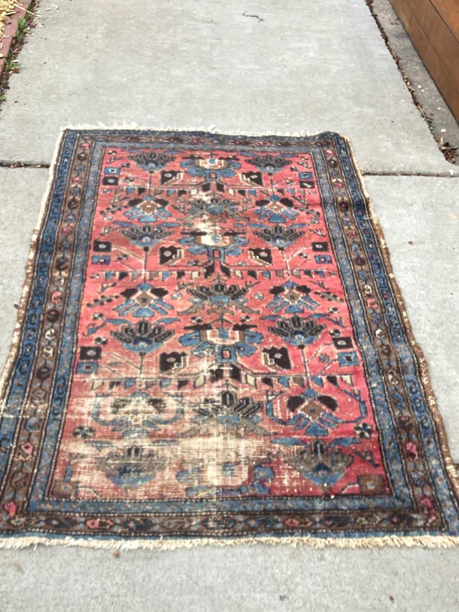 hand made antique wool rug with some wear 
