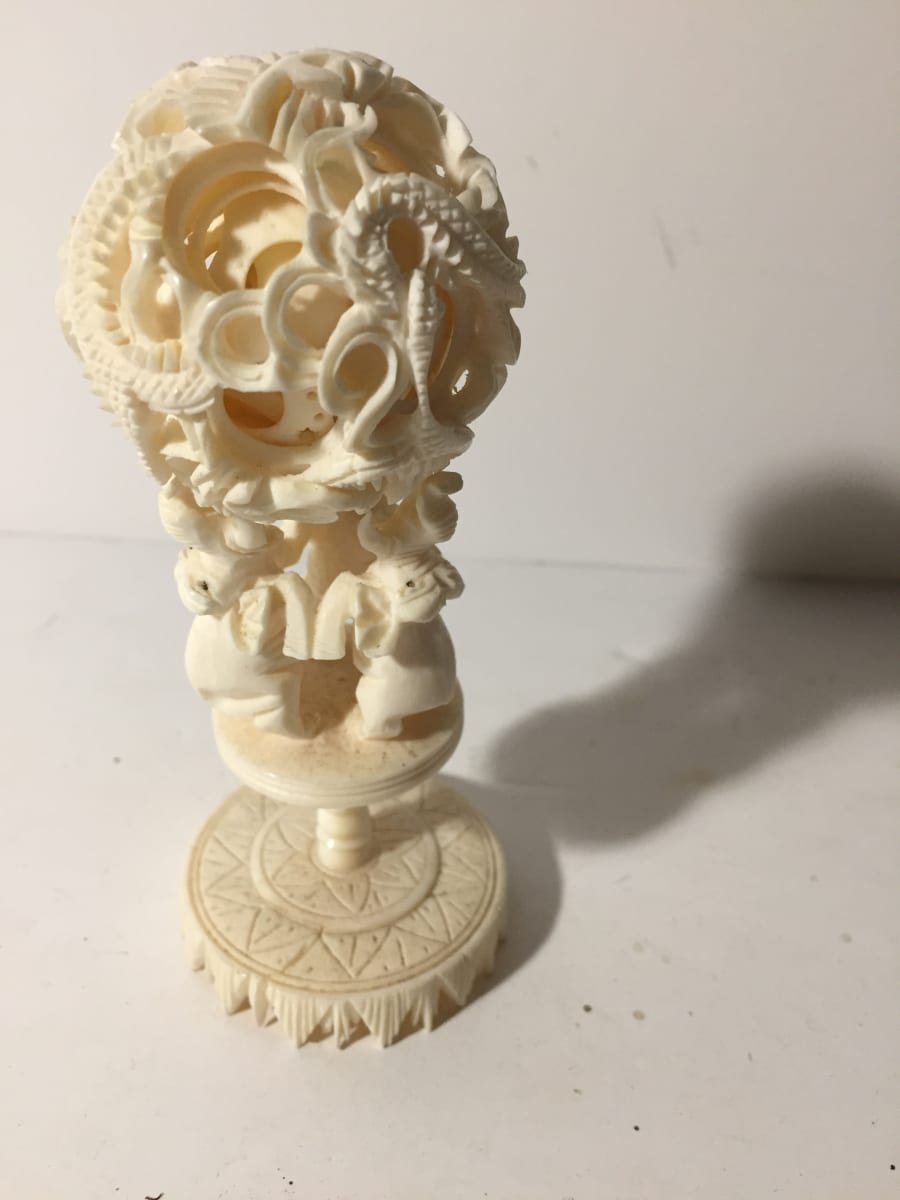 Carved bone elephant and ball item 