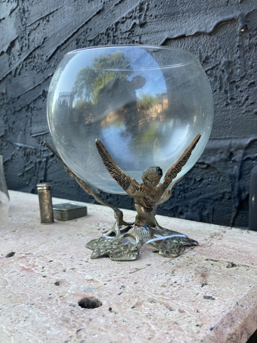 Winged metal figural base with glass bowl 