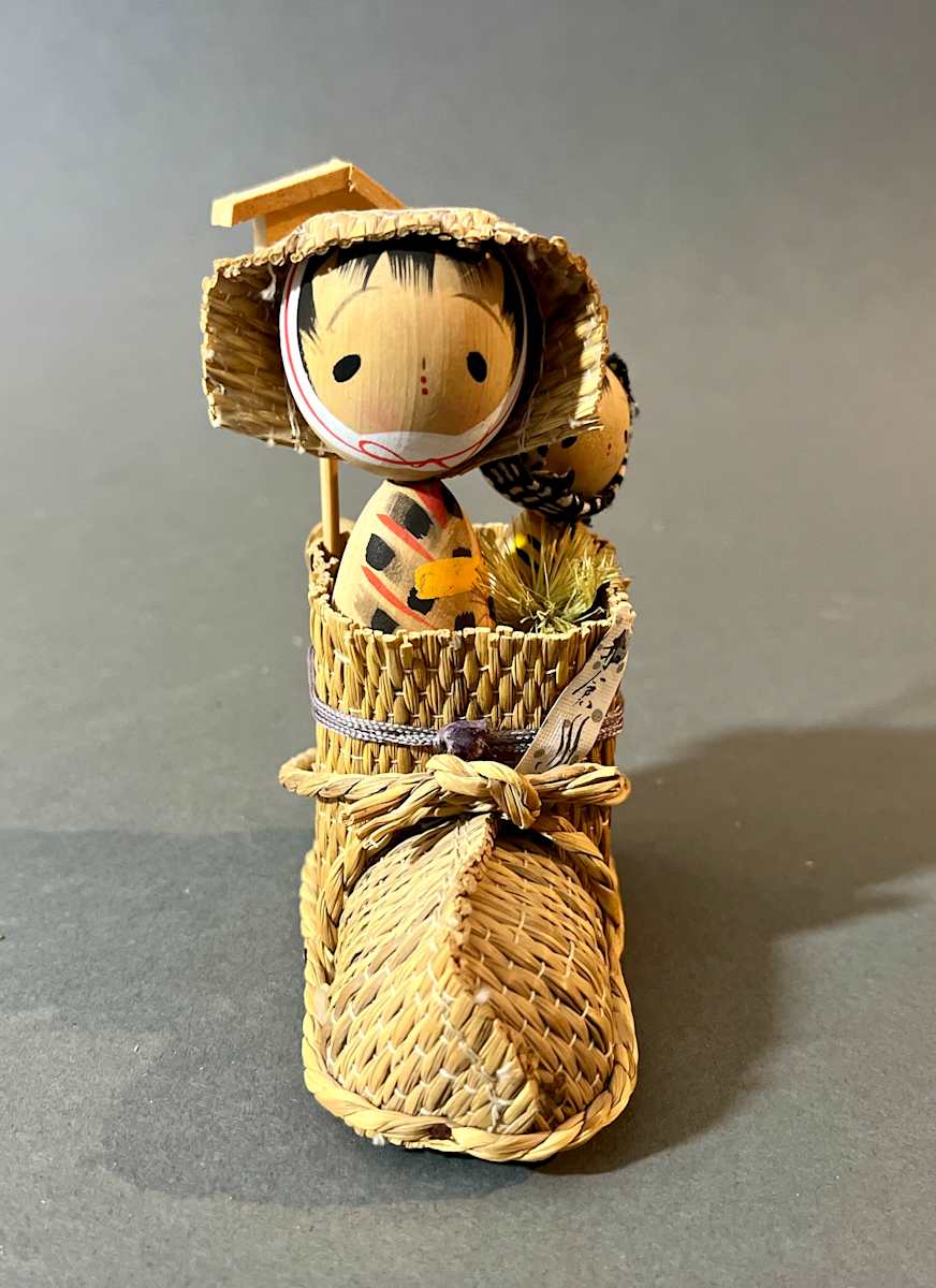 Kokeshi dolls in a straw boot 
