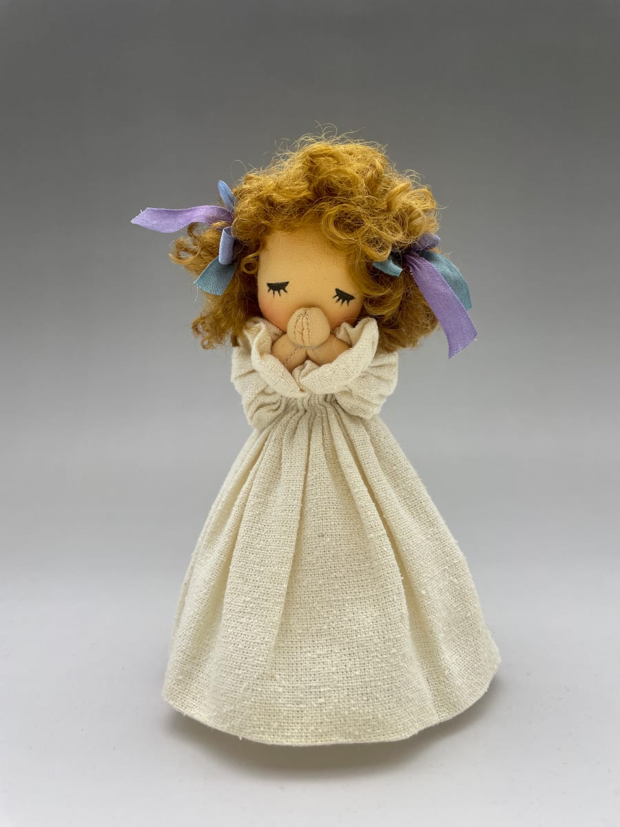 Little Prayer 2 by Moonyoung Jeong  Image: The praying child is expressed as a simple stuffing doll.
The artist's sign is written on the bottom of the doll