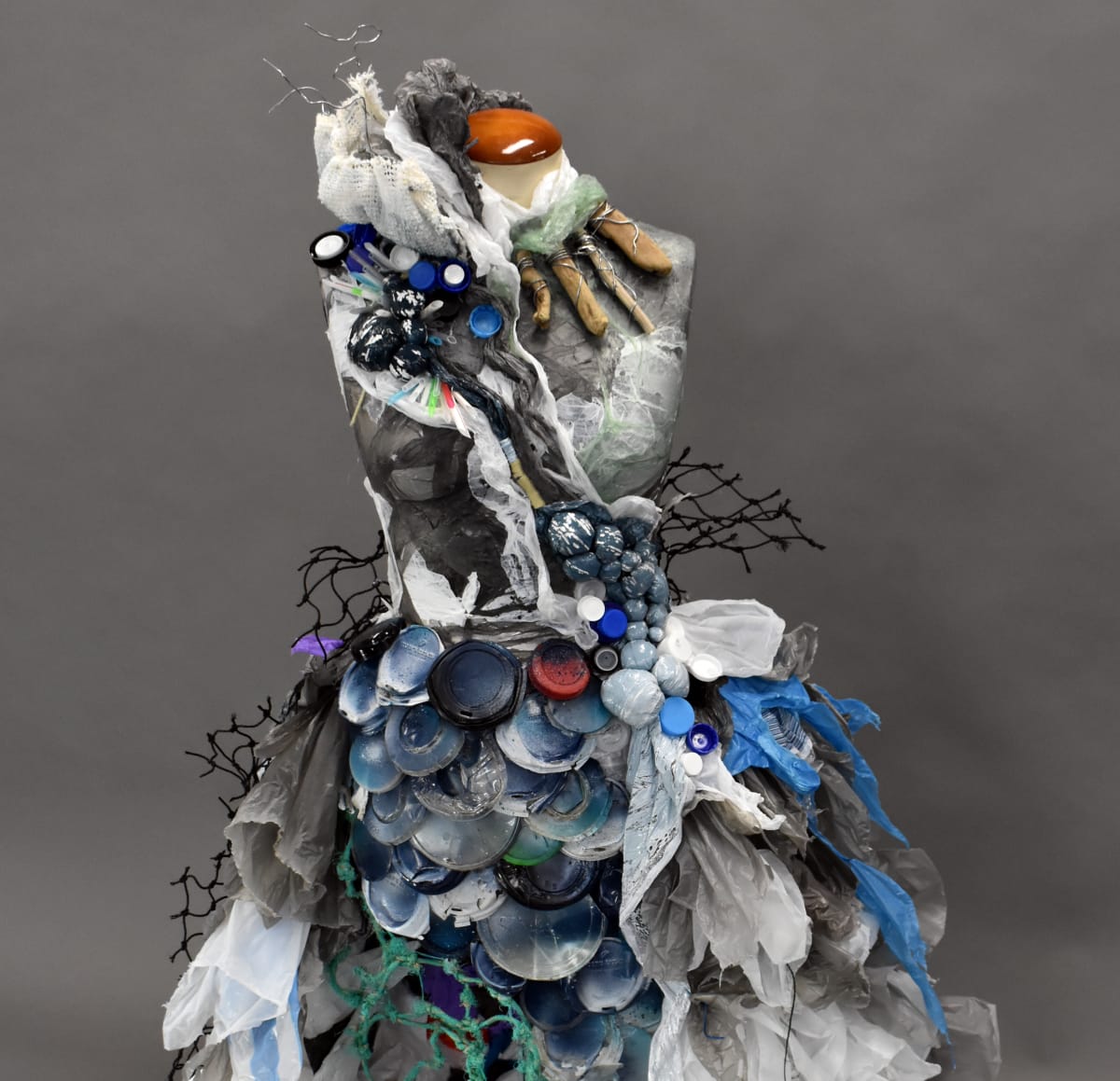 Recycled Materials by Angelica Sowa  Image: Unit 4 Studio Arts. Inspired by her interests, which are fashion and surfing. Angelica would notice plastic floating through the ocean as she surfed. She gathered this plastic and created this piece, using an iron to melt the plastics together in places. 