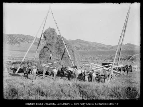 [Hay rig near Coalville] by George Beard  Image: Women, men, and children posing by a hay rig and stack of  hay.