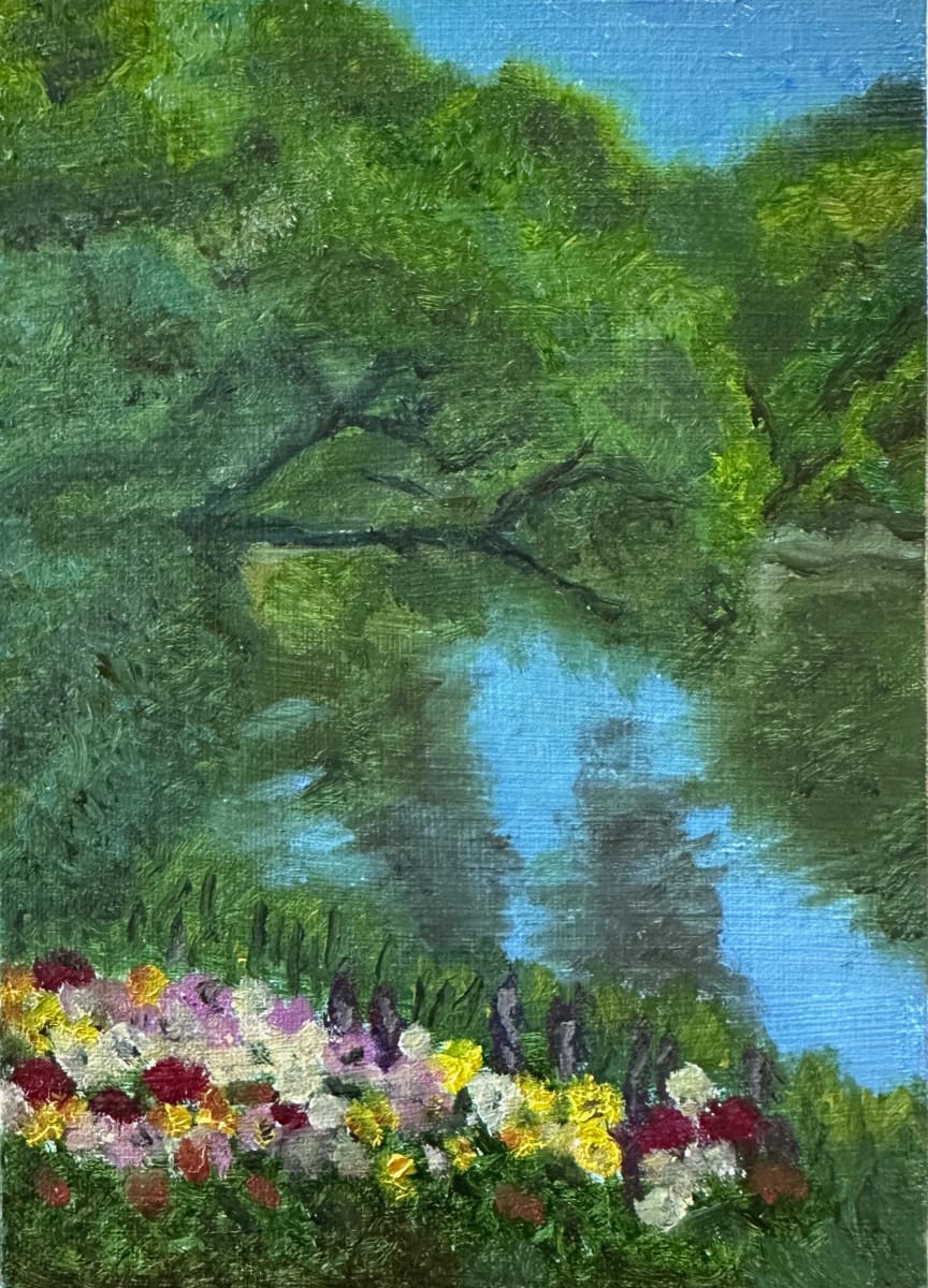 Art in the Park by Brian Hugh Wagner  Image: A serene pond is surrounded by lush green trees under a clear blue sky, with a cluster of vibrant flowers in the foreground. The reflection of the trees in the pond adds a sense of tranquility to the scene.