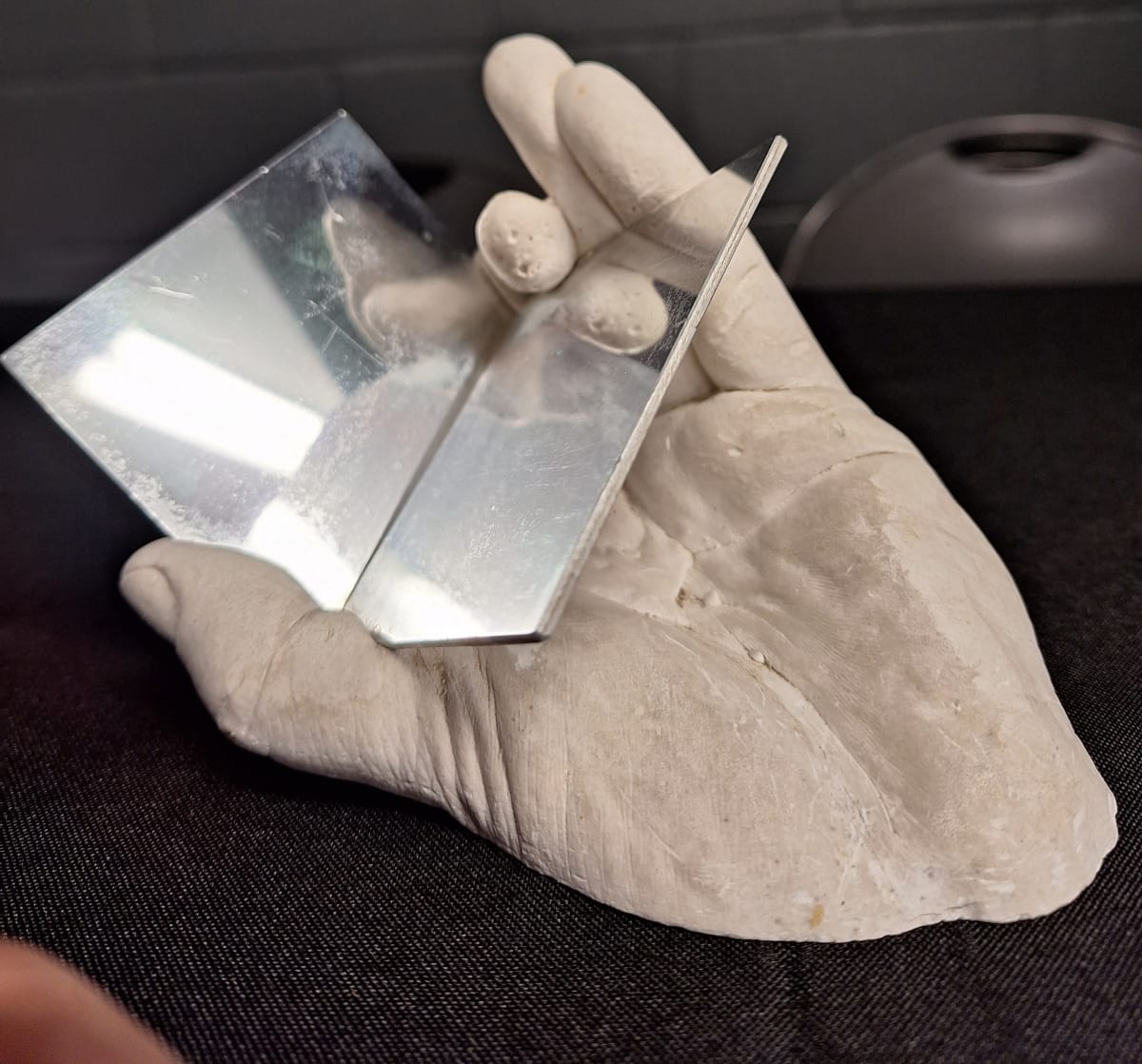 Hand Holding Polished Metal Sculpture 3-D by Hans Breder  Image: Hand Holding a Cube Sculpture 3-D