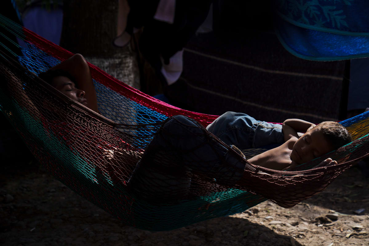 Asylum-seeking father and son sleep in an encampment near the International Bridge in Matamoros, México by Verónica G. Cárdenas 