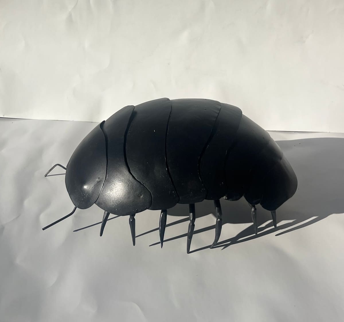 Pill Bug by Mina Koonz  Image: Mina Koonz, "Pill Bug", 2024, sheet metal and steel with black magic patina, 6 x 11 x 8 in.