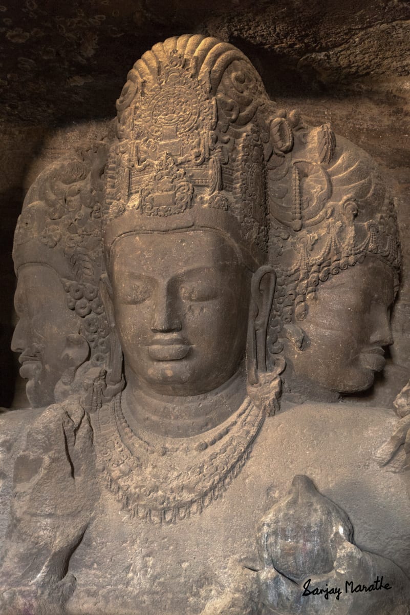 Sadashiva Sculpture, Elephanta Caves, Mumbai (2016) by Sanjay Marathe  Image: This majestic masterpiece, the 7-meter high three headed Shiva is located deep inside a rock cut cave at Elephanta island near Mumbai. Though sculpted in the very hard basalt rock, it beautifully depicts the serene expressions. The sculpture represents the three aspects of Shiva: the Creator, the Preserver, and the Destroyer. It dates back to the mid 5th - 7th century CE. With very low available light and no tripods permitted, I had to photograph it handheld, with a digital SLR camera.
