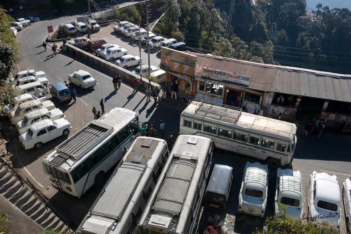 Taxi Stand, Mussoorie (2005) by Sanjay Marathe  Image: White Ambassador taxis and buses parked at the entrygate of Mussoorie town, in Uttarakhand, India.