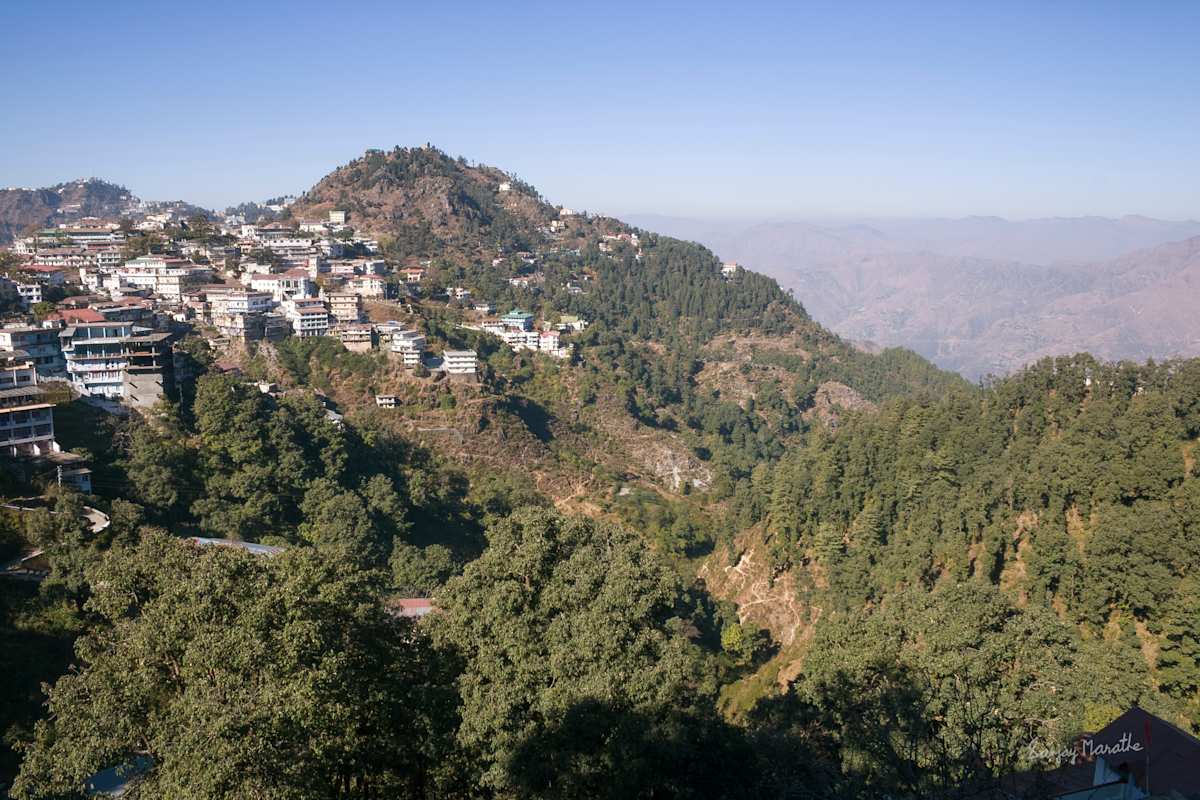 Mussoorie Hills Landscape-2 (2005) by Sanjay Marathe  Image: A view of Mussoorie town nestled among tree-covered hills in Uttarakhand, India.