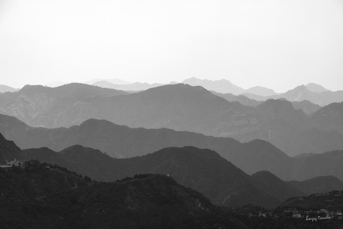 Rolling Hills-2, Mussoorie (2013) by Sanjay Marathe  Image: A stunning view of the rolling hills in Mussoorie, Uttarakhand, where the mountains extend endlessly into the horizon. The landscape, with its layered ridges and striking contrasts, evokes a sense of serenity and contemplation, beautifully captured in monochrome tones.