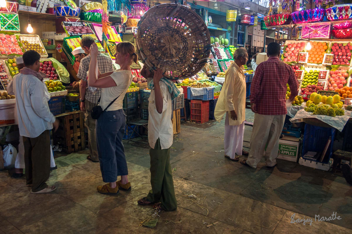 Inside Crawford Market , Mumbai (2006) by Sanjay Marathe  Image: Tourists and shopkeepers interact with the fruit vendors at the Crawford market in Mumbai, India.