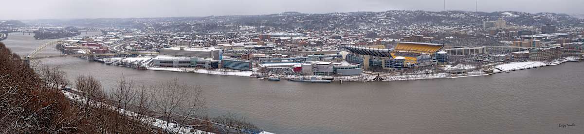 Pittsburgh Panorama-1 (2025) by Sanjay Marathe  Image: A panoramic view of Pittsburgh’s Ohio River and cityscape, captured from the Mount Washington overlook on a windy, sub-zero day. After two days of snowfall, the city lies blanketed in white. This expansive panorama was crafted by stitching together five frames clicked in quick succession, showcasing the city’s winter beauty in its full expanse.