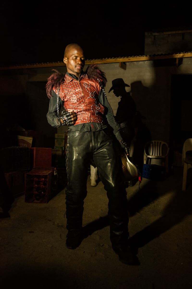 Untitled by Daniele Tamagni Foundation  Image: A Congolese metal fan wearing a red, studded leather gilet embellished with chains and a fur collar.
