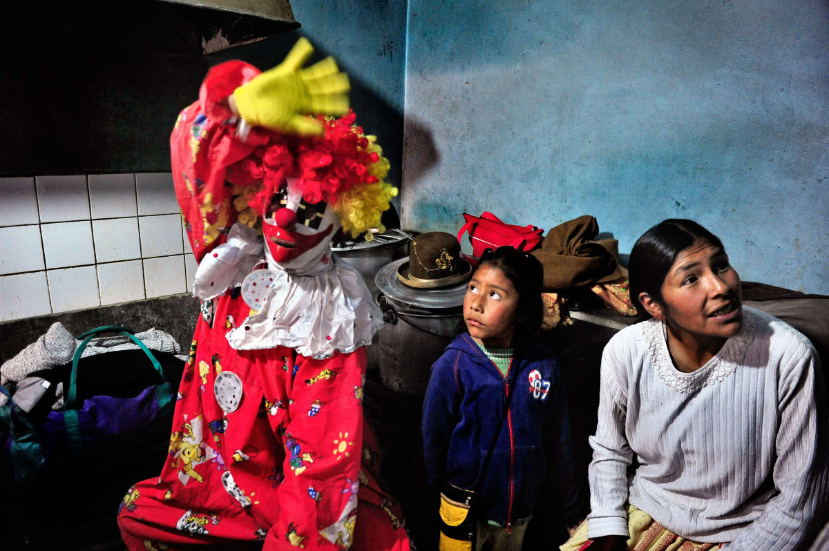 Untitled  Image: A clown-costumed luchador in the backstage room with Dina and one of her kids.