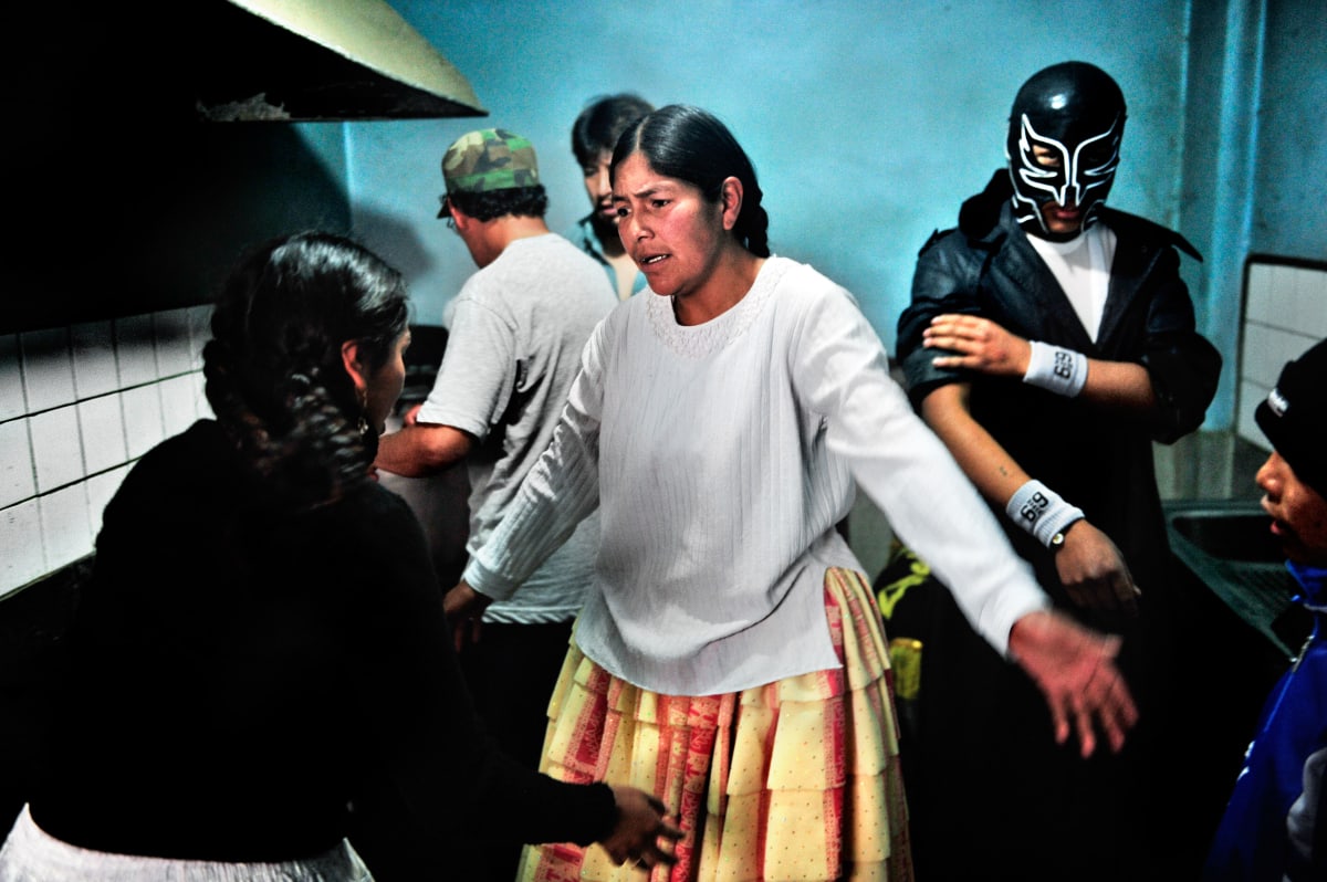Untitled  Image: Dina and a group of luchadores in the backstage room during a show.
