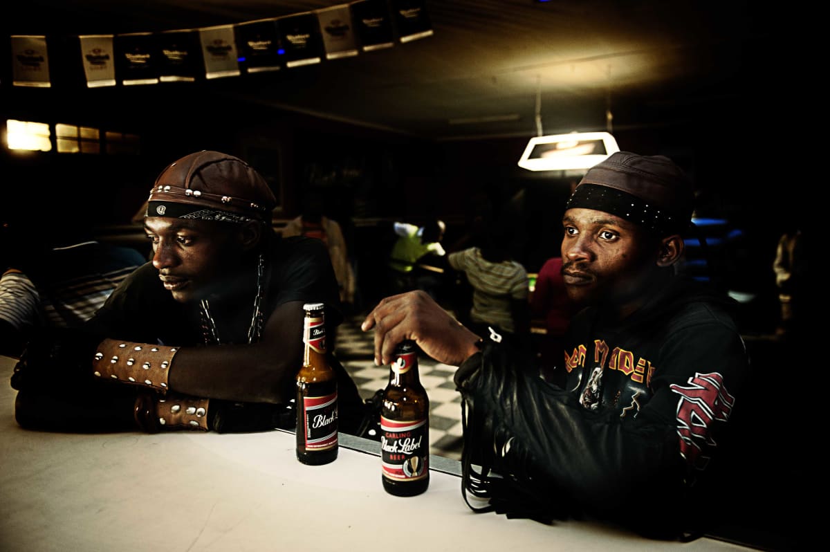 Untitled  Image: Two metal fans having a beer at the counter.