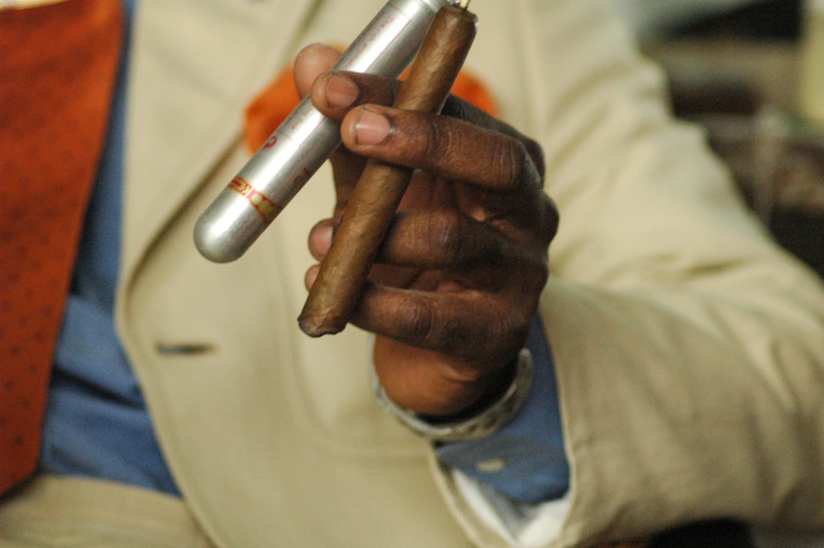 Untitled  Image: Close up photograph of Phael's hand holding a cigar and its case. Brazzaville, Congo (2007)