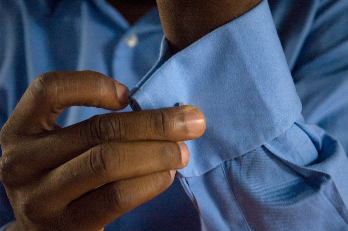 Untitled (Salvador Hassan getting dressed #1)  Image: Close up of Salvador Hassan closing the cuffs of his blue shirt. Brazzaville, Congo (2007)
