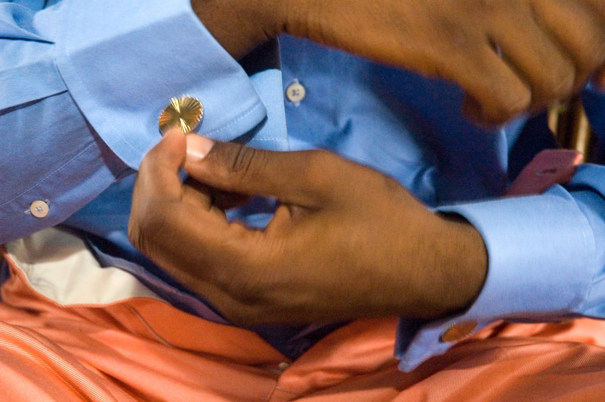 Untitled (Salvador Hassan getting dressed #2)  Image: Close up of Salvador Hassan inserting golden cufflinks into his shirt. Brazzaville, Congo (2007)
